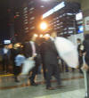 ５月２４日２０時頃、新宿駅南口にて。人と同じ数だけ傘が動く。